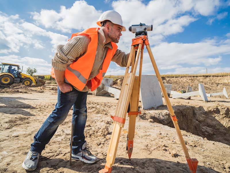 man looking through surveying equipment